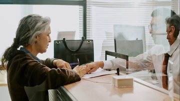 Beneficiários do INSS convocados também podem realizar a prova de vida presencialmente em uma agência bancária - Envato
