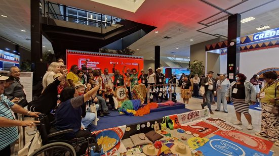 Delegação de São Paulo posa com faixas e bandeiras no espaço cultural Paulo Freire da 6ª Conferência Nacional da Pessoa Idosa - Paula Bulka Durães/Viva