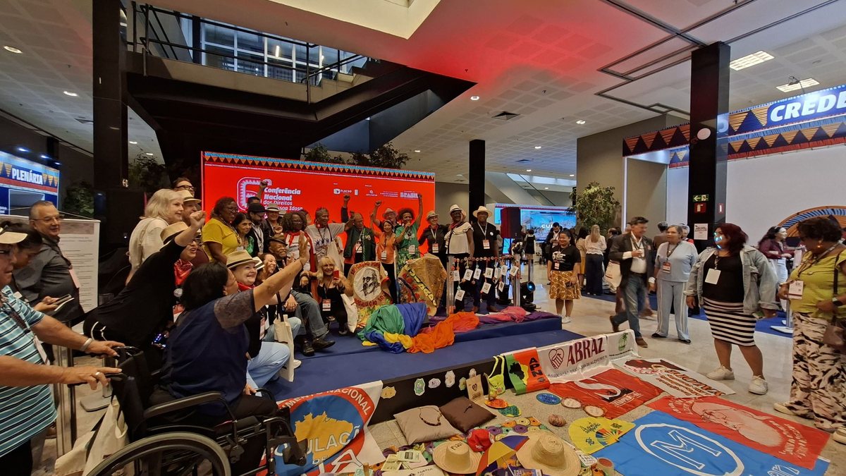 Delegação de São Paulo posa com faixas e bandeiras no espaço cultural Paulo Freire da 6ª Conferência Nacional da Pessoa Idosa - Paula Bulka Durães/Viva