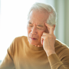 Idosos frequentemente relatam dor nos dois lados da cabeça e menor sensibilidade à luz e ao som - Adobe Stock