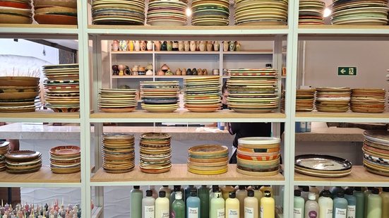 Estante com cerâmicas prontas e produtos para a pintura da peça - Alessandra Taraborelli