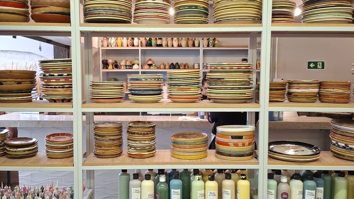 Estante com cerâmicas prontas e produtos para a pintura da peça - Alessandra Taraborelli