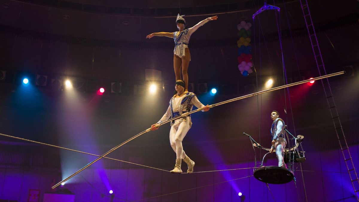 Artistas de circo se apresentam em número de equilíbrio sobre corda bamba - Envato