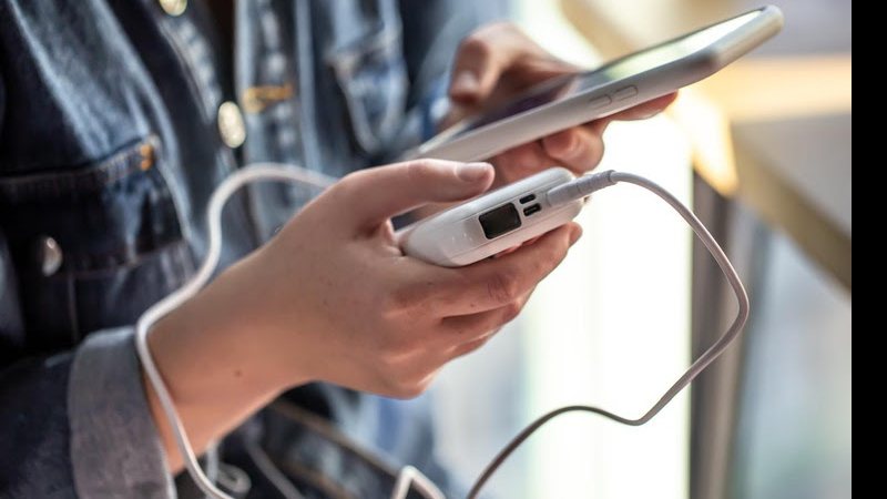 Usuário carrega um celular com um power bank; novas regras impõem limites à quantidade e potência dos aparelhos - Divulgação - Ministério de Portos e Aeroportos