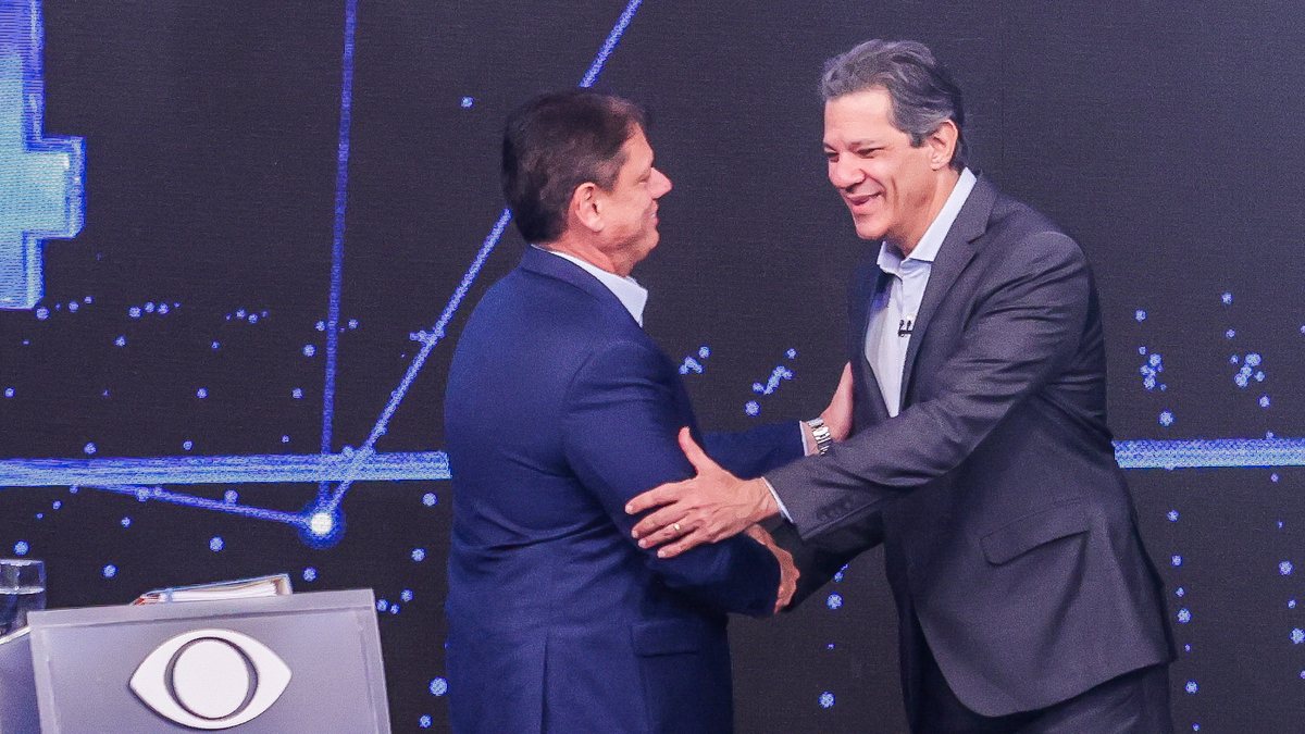 O governador de SP Tarcísio de Freitas (Republicanos) e o ex-prefeito Fernando Haddad (PT) se cumprimentam no início do debate da Band TV - Estadão Conteúdo