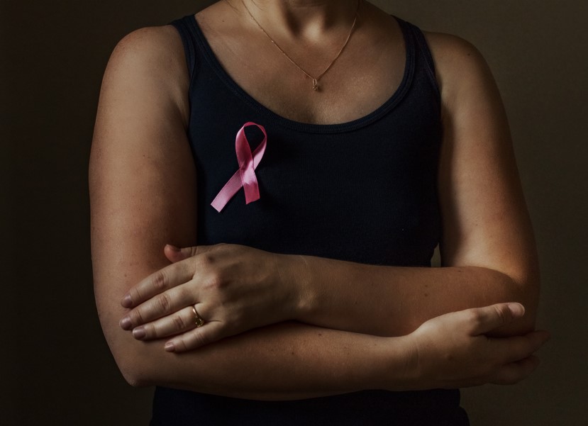 mulher usando blusa com selo do câncer de mama