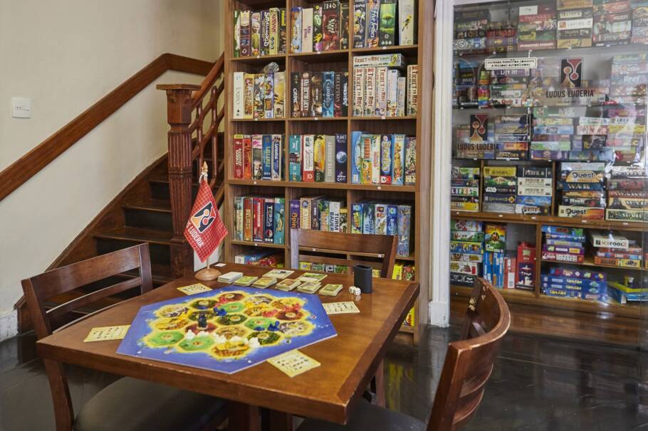 Armário de jogos do bar Ludus, em São Paulo, com várias opções de jogos de tabuleiro e cartas