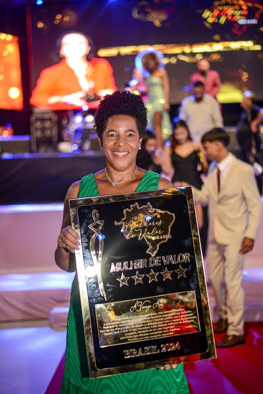 Mulher negra recebendo prêmio por empreender