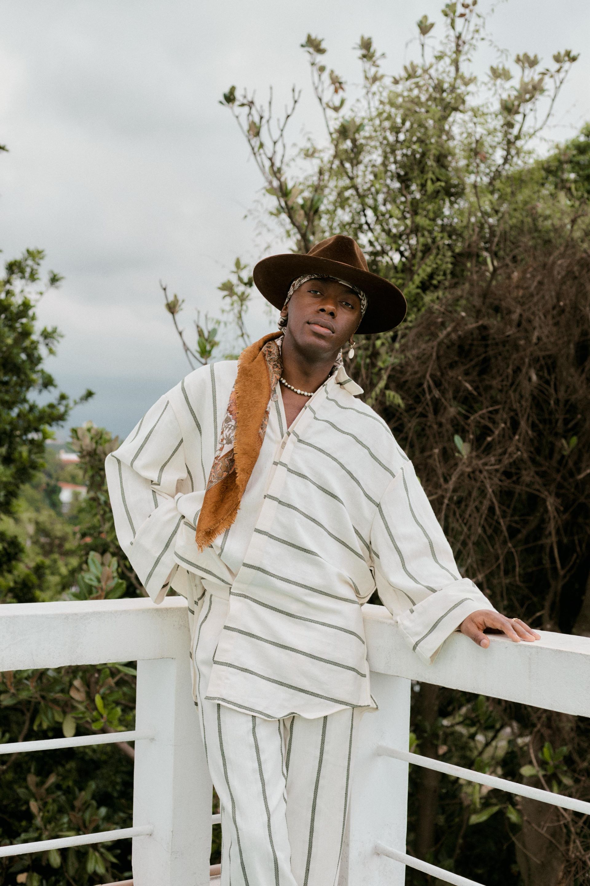 Cantor Jotapê pousa para foto com roupa branca e listra preta