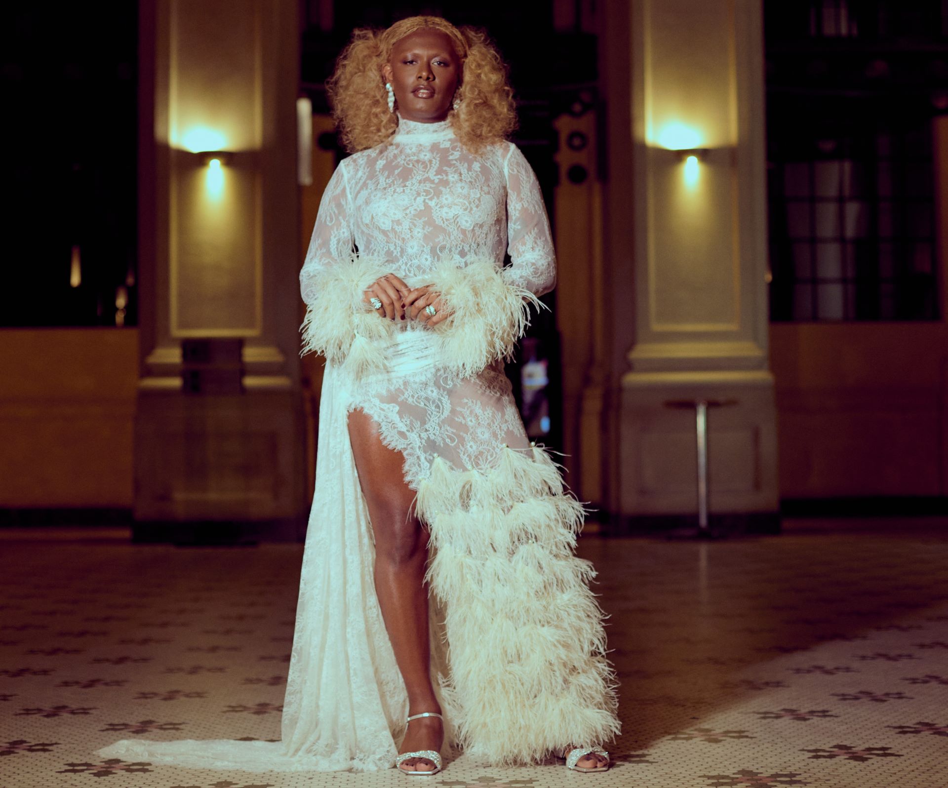 A cantora Liniker de vestido branco posando para foto