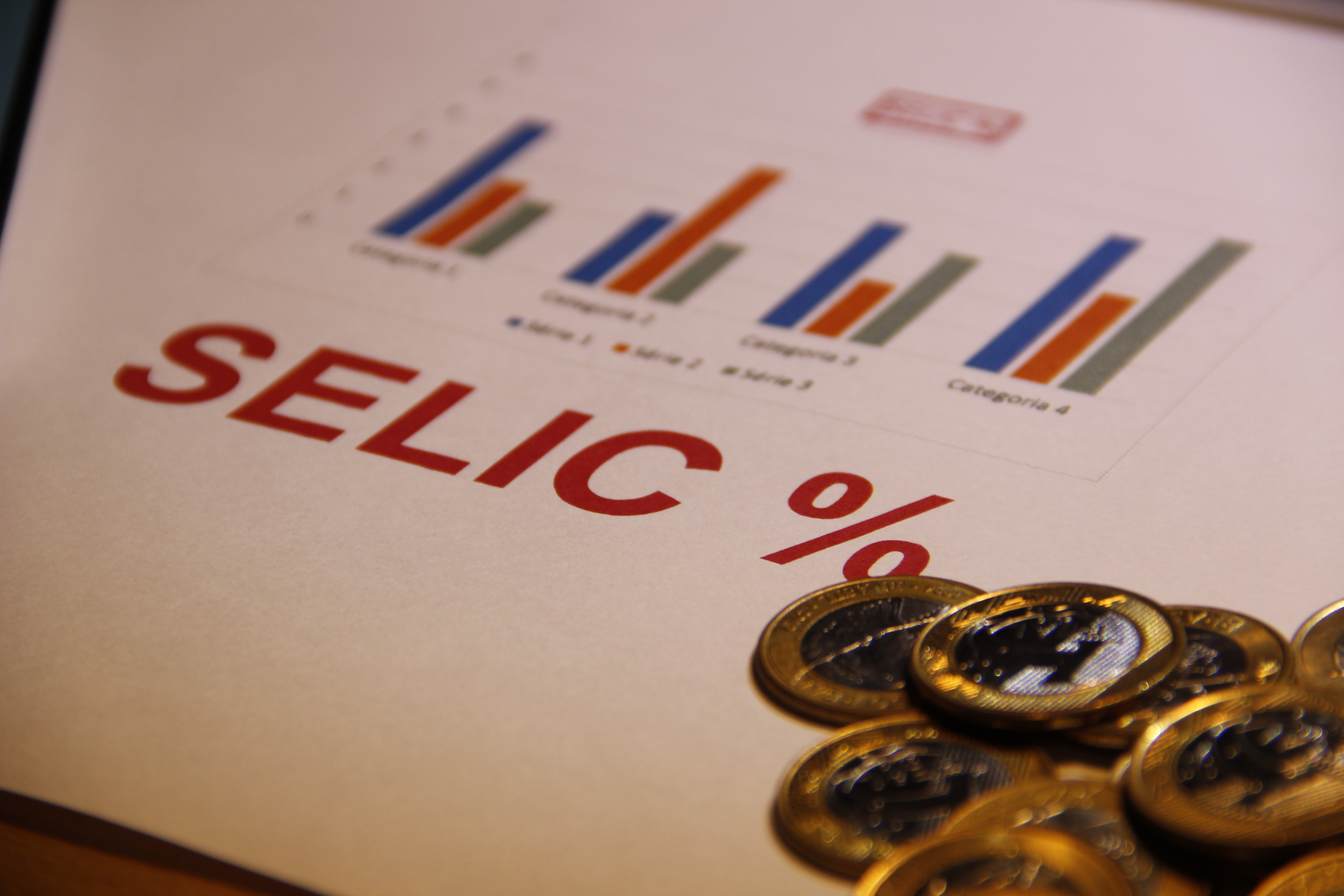 gráficos e moedas ao lado da palavra selic