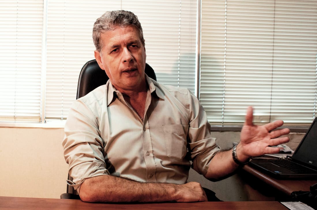 Mário Avelino sentado em sua mesa gesticula com as mãos 