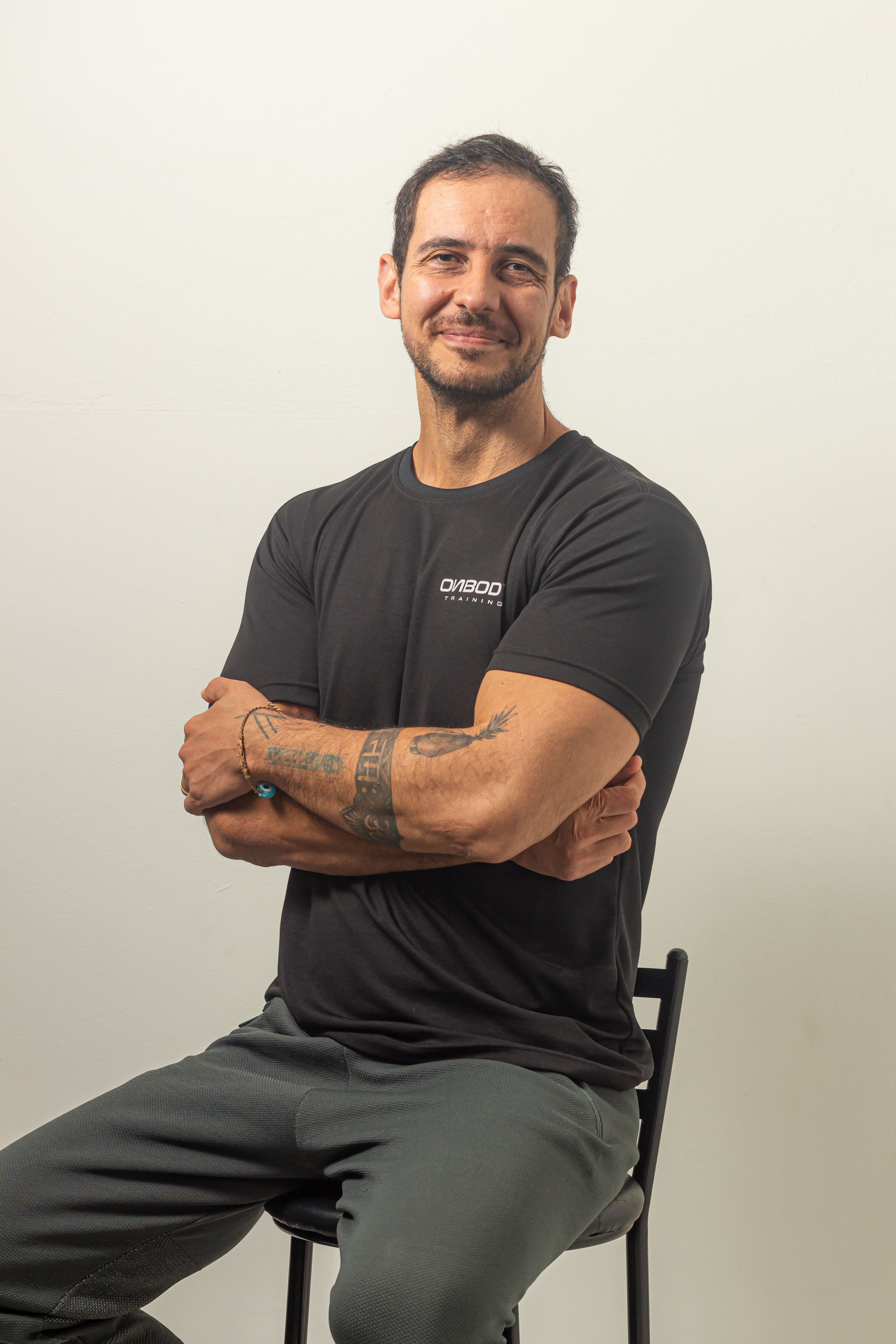 Treinador físico Felipe Kutianski de braços cruzados, sentado