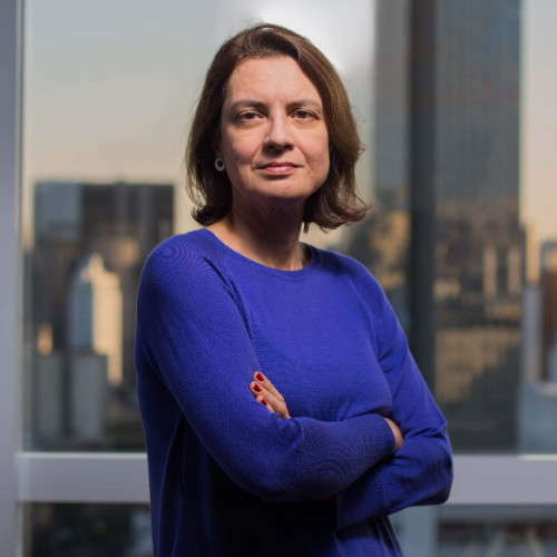 Ana Julião é uma mulher adulta com cabelos curtos e castanhos claros, está de braços cruzados, com uma camisa azul 