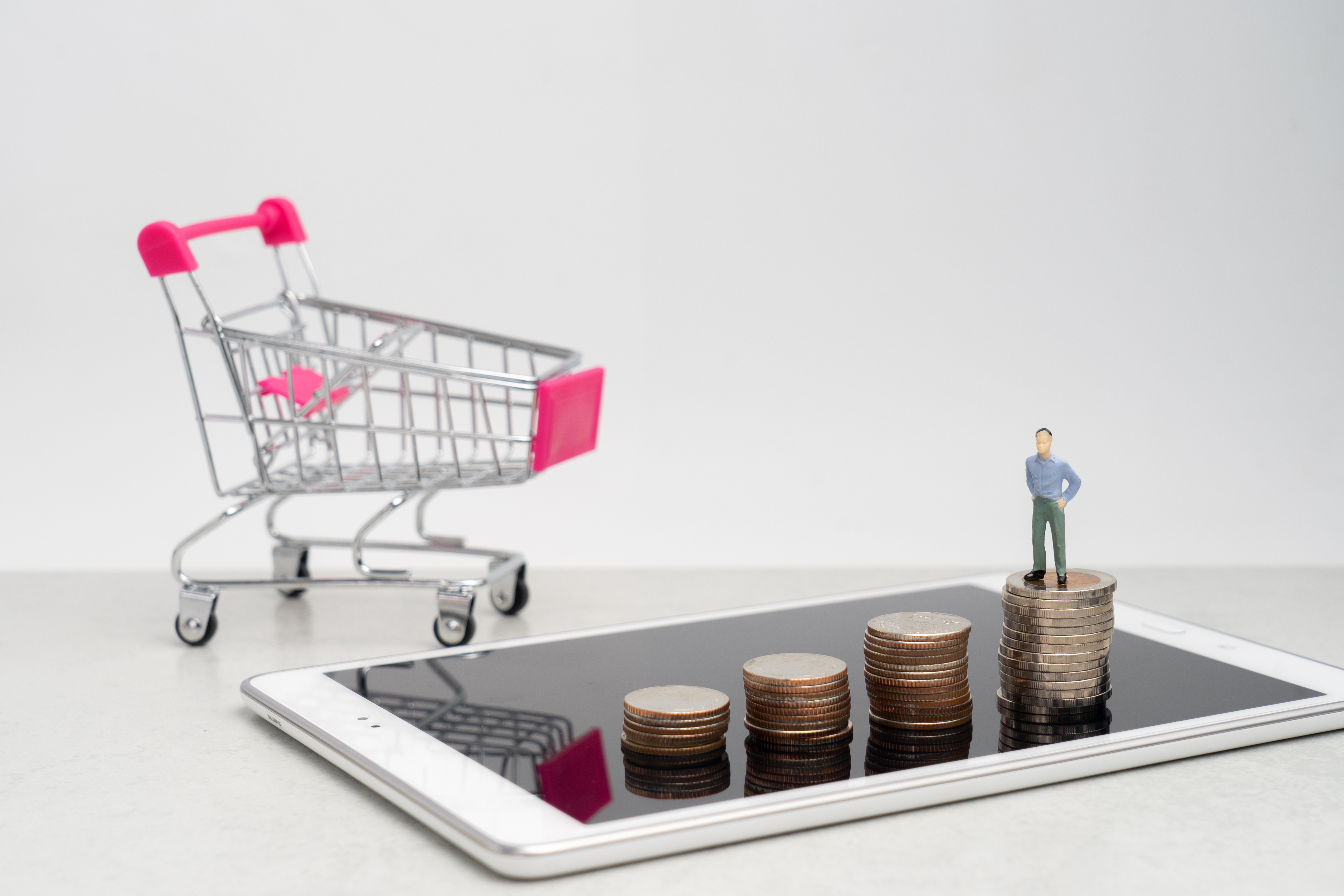 montagem mostra carrinho de compra, tablet e uma miniatura de homem