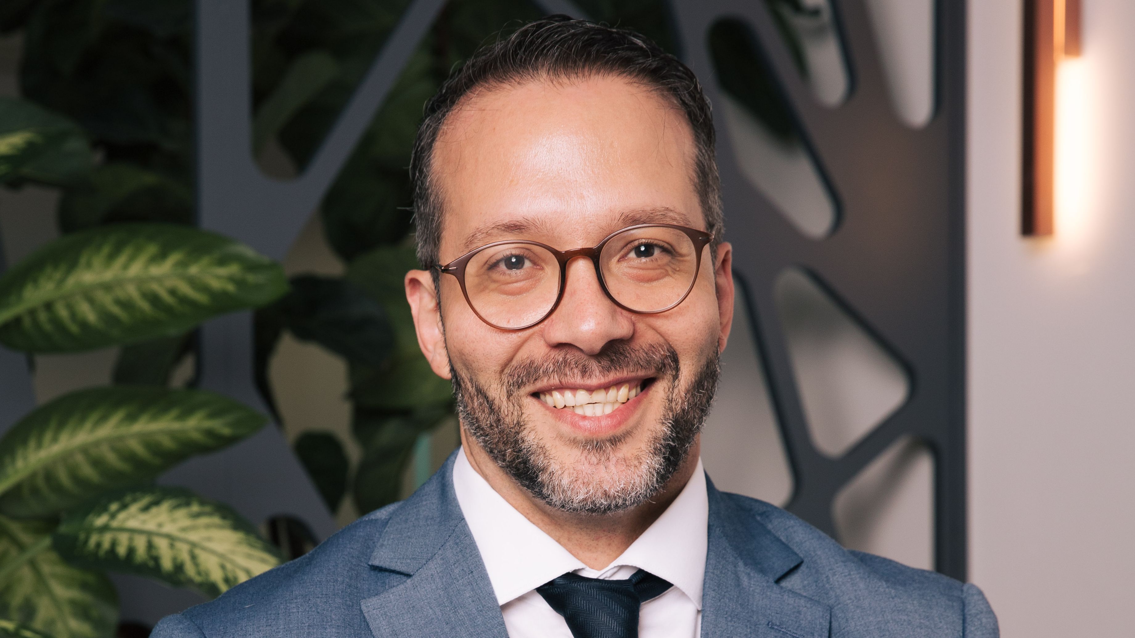 Elias Menegale, tributarista, homem, branco de óculos e terno cinza