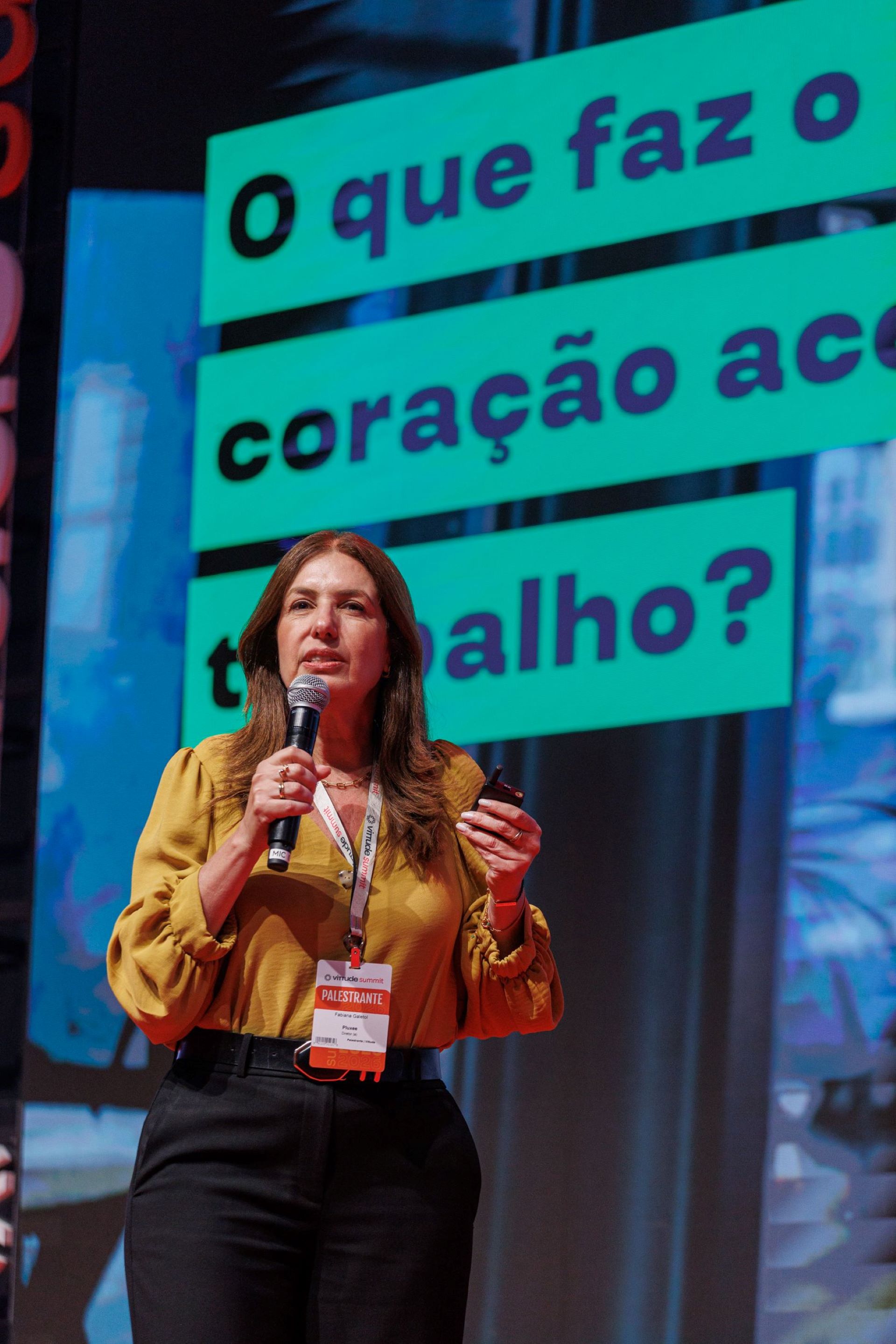 Fabiana Galetol com o microfone na mão fala durante palestra no Vittude Summit 2026