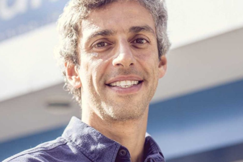 Thomaz é um homem branco e magro com cabelos grisalhos que sorri para a foto