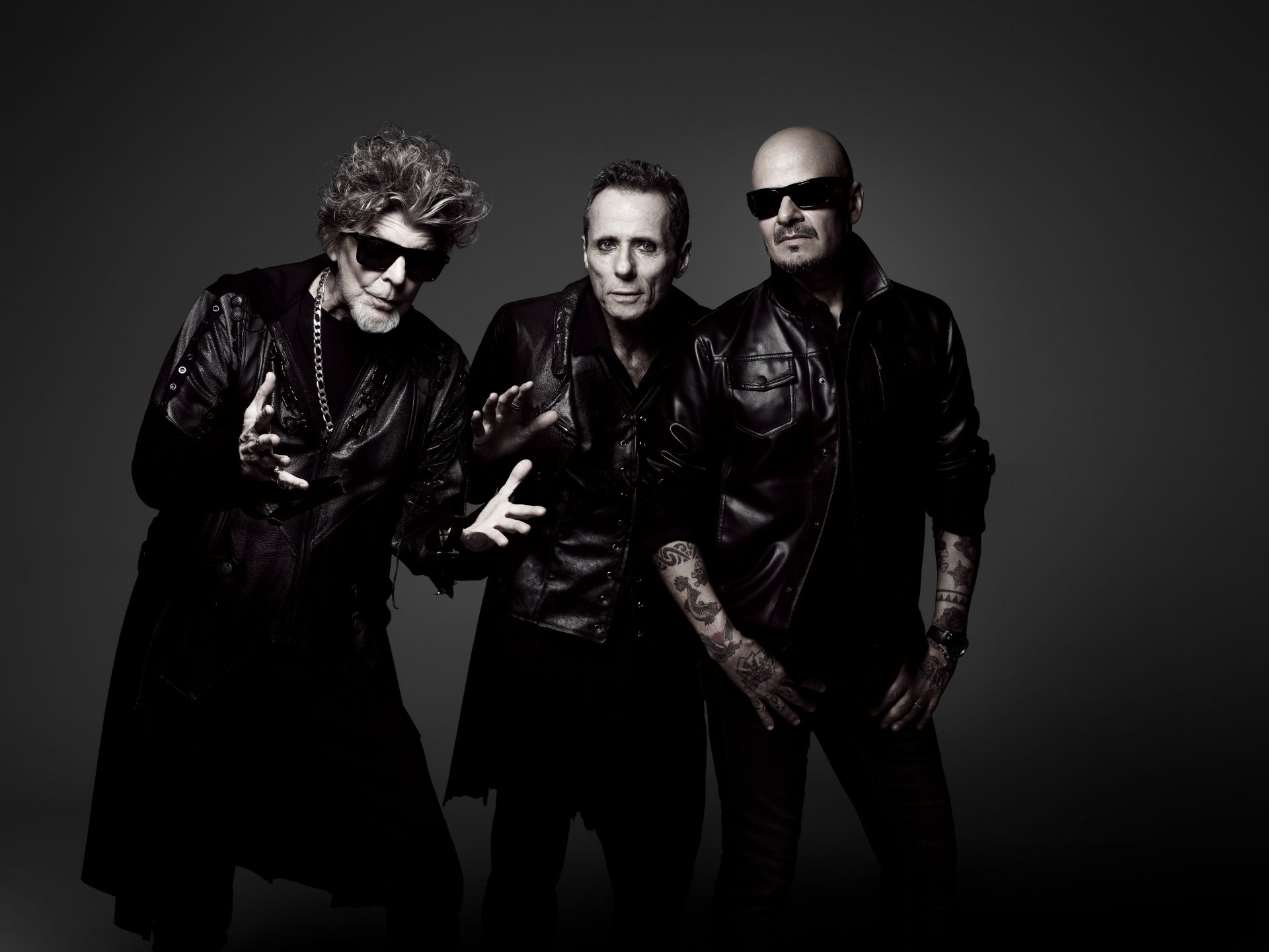 Branco Mello, Tony Bellotto e Sérgio Britto, dos Titãs, usam roupa preta e estão posicionados um do lado do outro