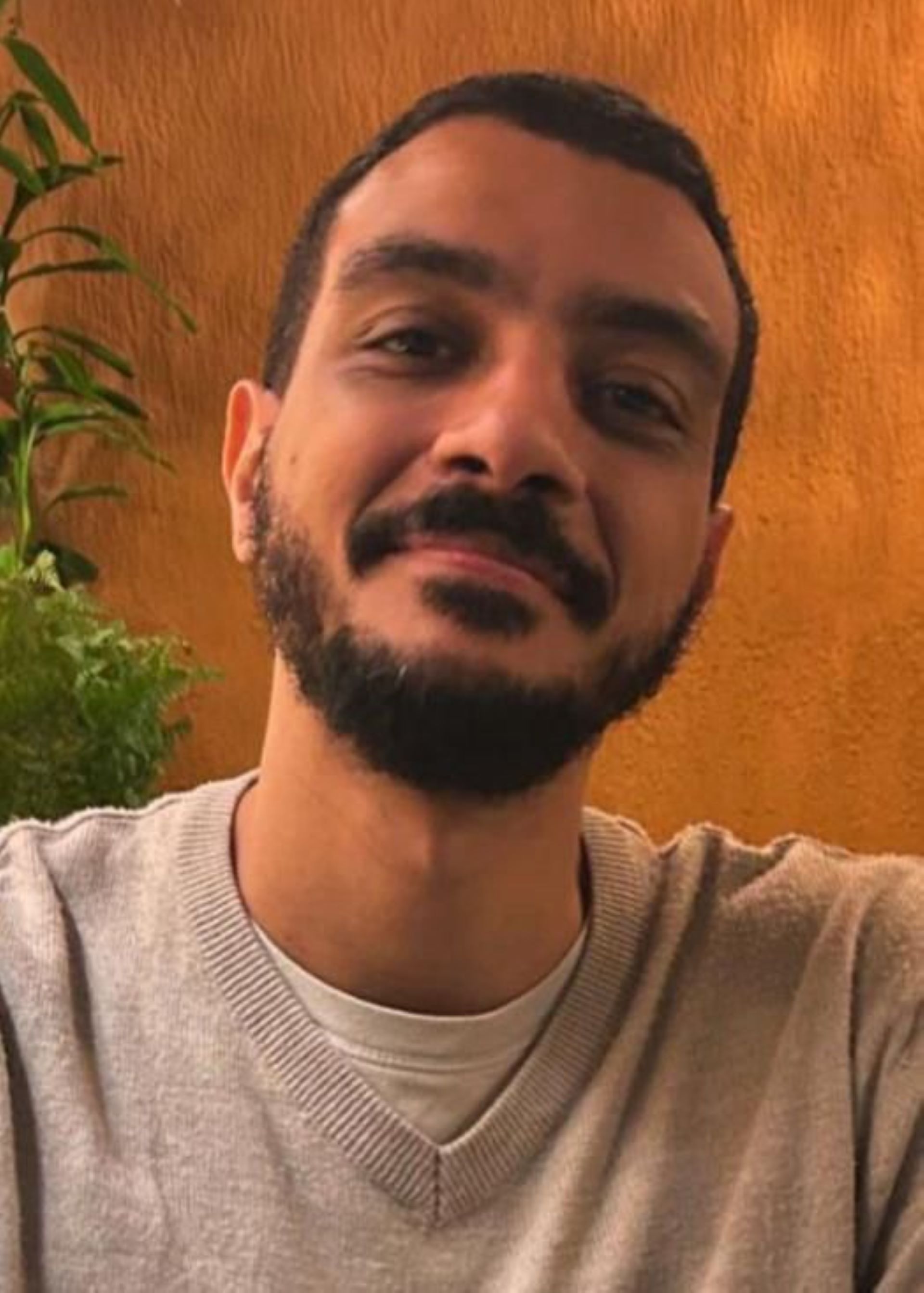 Gabriel Chaves, de barba e bigode, sorri; usa camiseta acinzentada