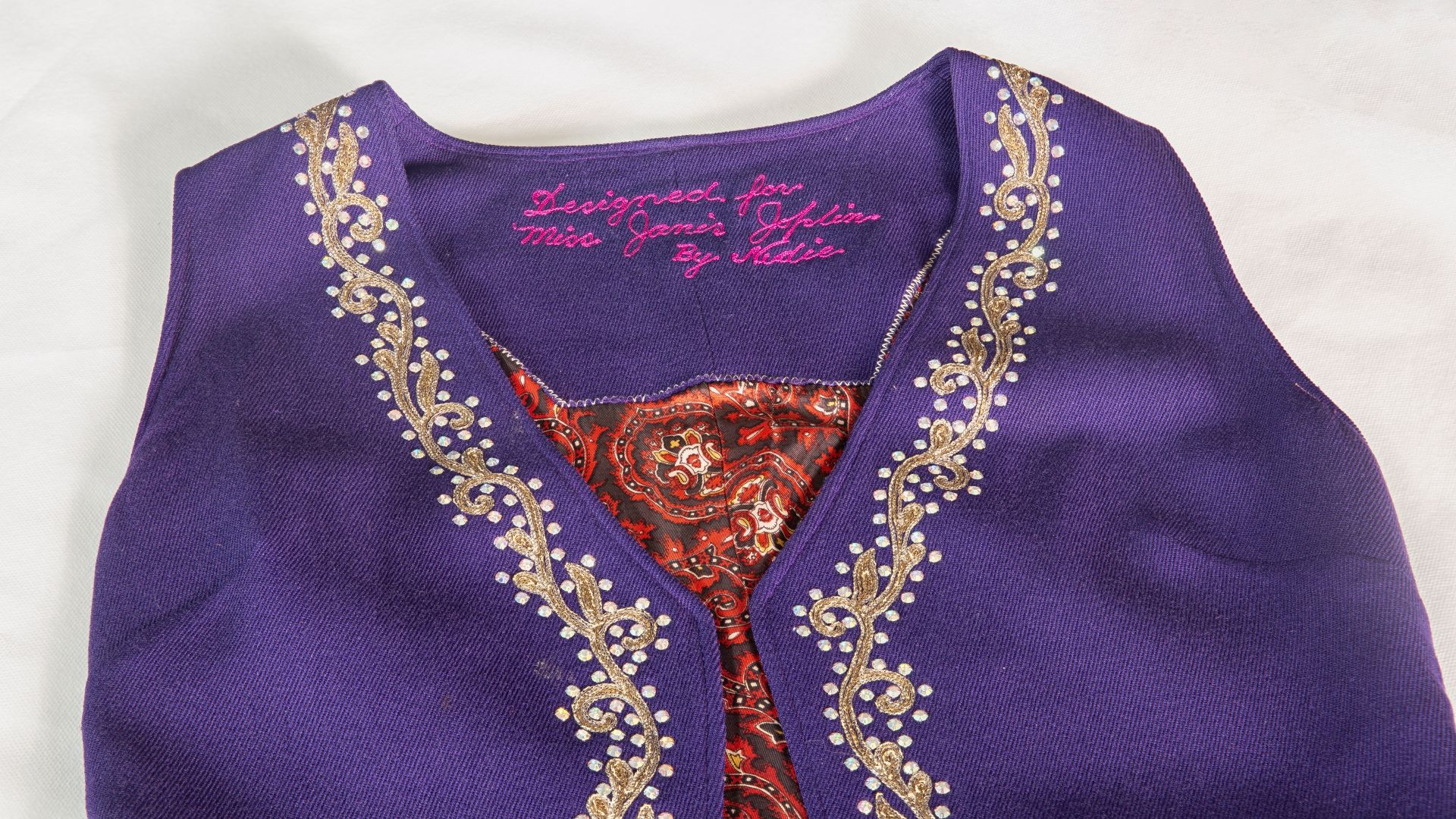 Colete roxo com bordados usado por Janis Jopli