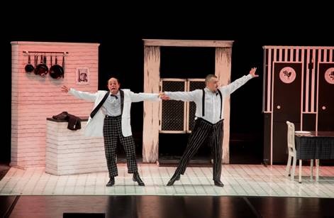 Os atores da Cia Los Circo estão em cima do palco, um segurando a mão do outro