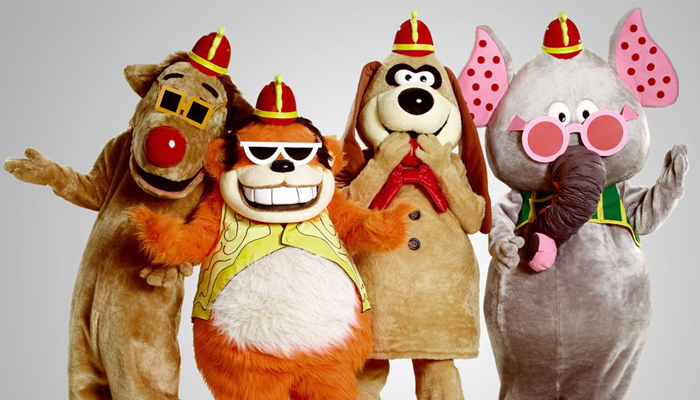 Os quatro integrantes do Banana Splits estão de pé e são pessoas vestidas com fantasia de bichos