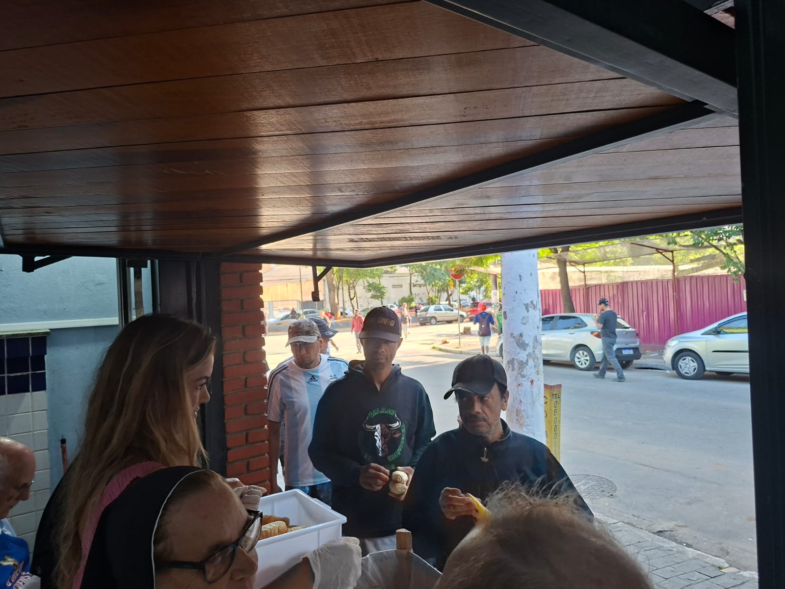 Pessoas formam fila para tomarem café distribuídos pela igreja  