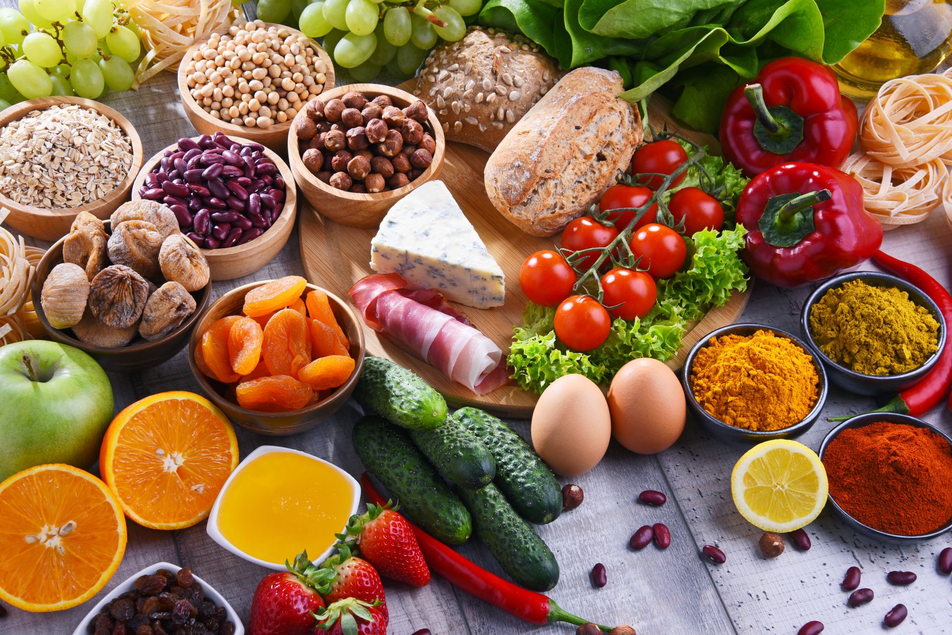 Mesa com legumes, queijos e outros alimentos
