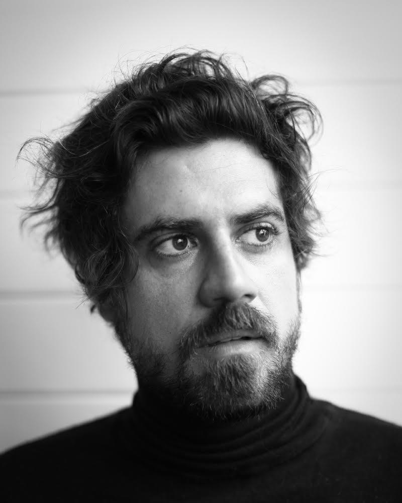 Renan Flumian está olhando para o lado, em uma foto preto e branco