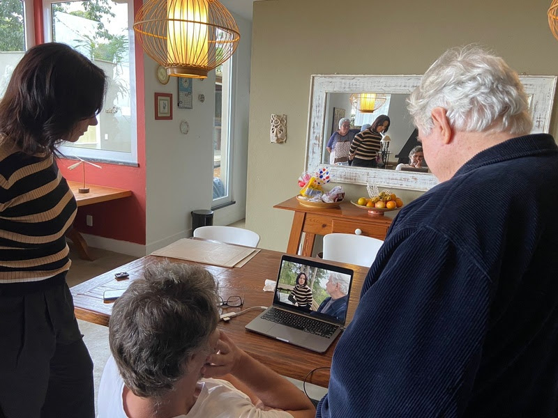 Diretor e Reginaldo Faria estão verificando a cena filmada em um notebook