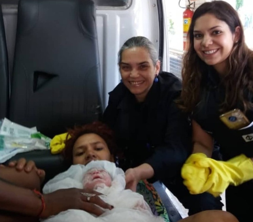 Pedro nos braços da sua mãe, junto das agentes do metrô