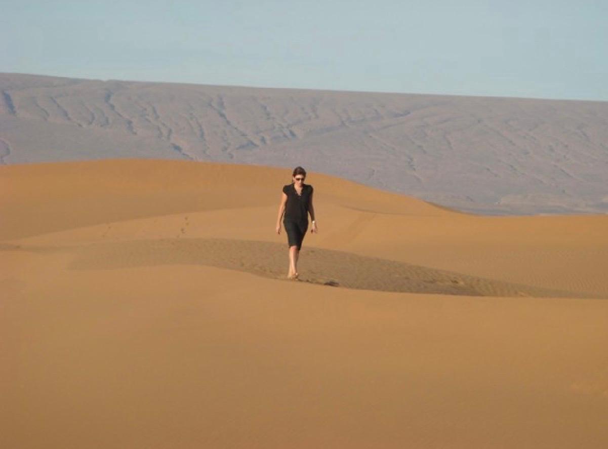 Empresária caminhando em meio a Dunas  no deserto do Saara