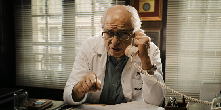Como o personagem, em cena, ele está com o telefone com o ouvido, discutindo 