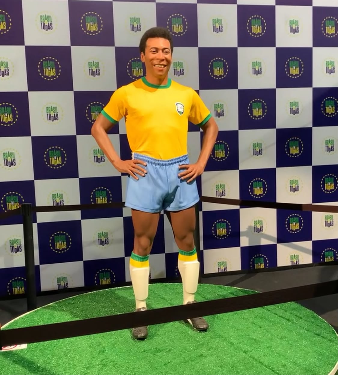 Estátua reproduzindo Pelé em tamanho real, com camisa amarela da seleção brasileira e shorts azul