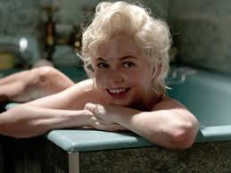 Michelle Williams está dentro de uma banheira, sorrindo