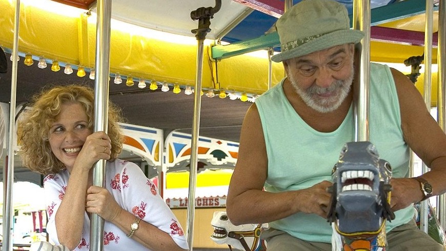 Os personagens de Irene Ravache e Lima Duarte estão se divertindo em um carrossel