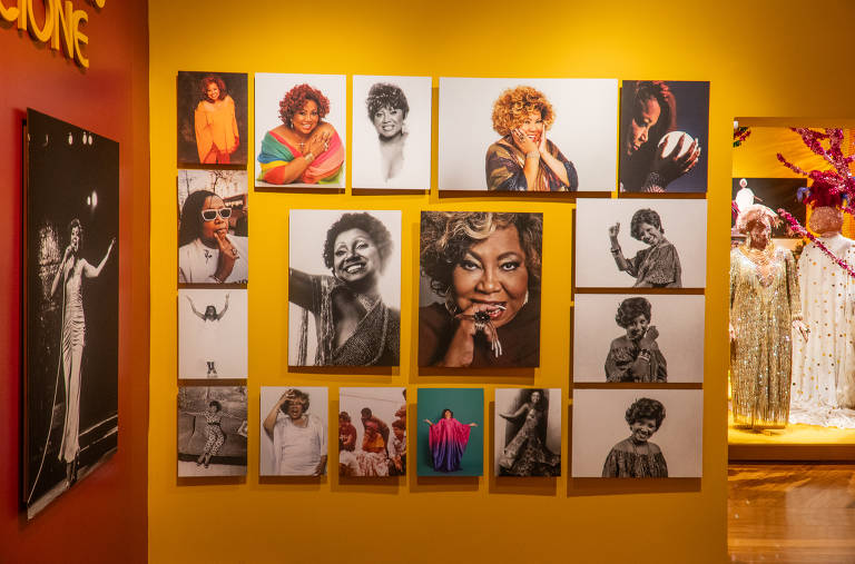 Parede amarela da exposição ‘Com Amor, Alcione’ reúne uma série de fotos da cantora