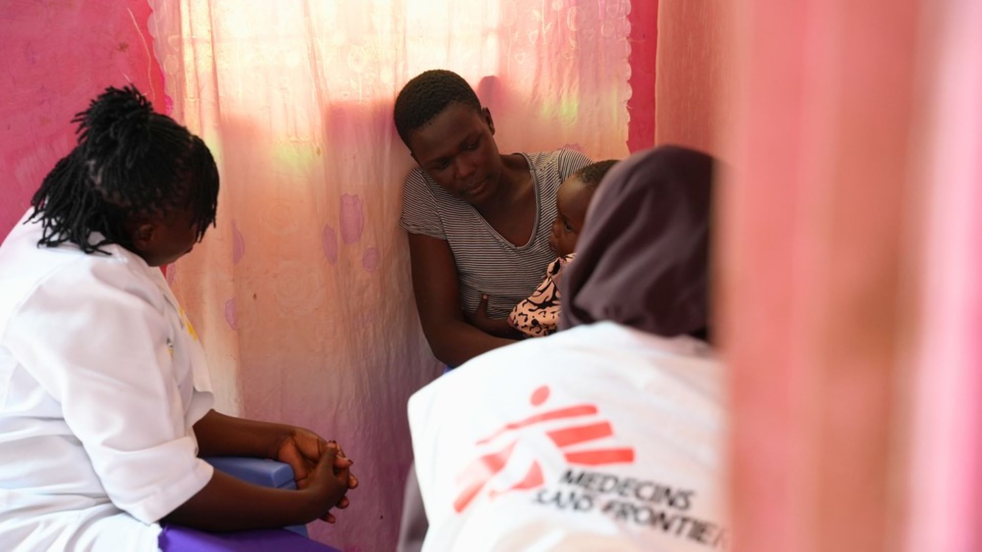 Mãe com bebê no colo conversa com médica do MSF e outra médica