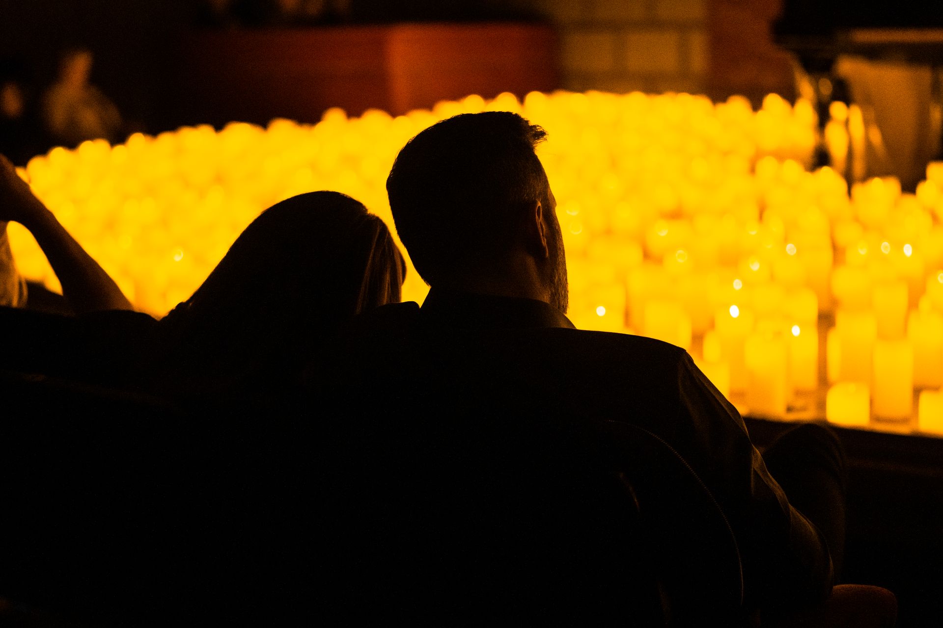 Sombra de casal junto com muitas velas cenográficas de fundo
