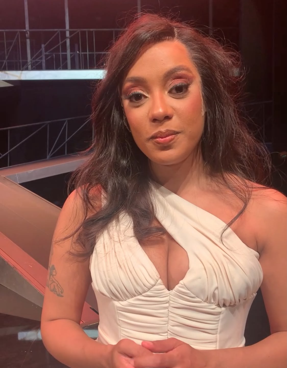 Luci Saluzzi tem cabelos longos lisos e usa vestido branco