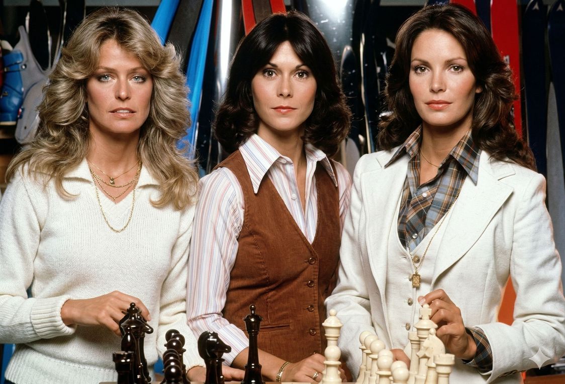 Farrah Fawcett, Kate Jackson e Jaclyn Smith estão lado a lado caracterizadas como suas personagens em As Panteras