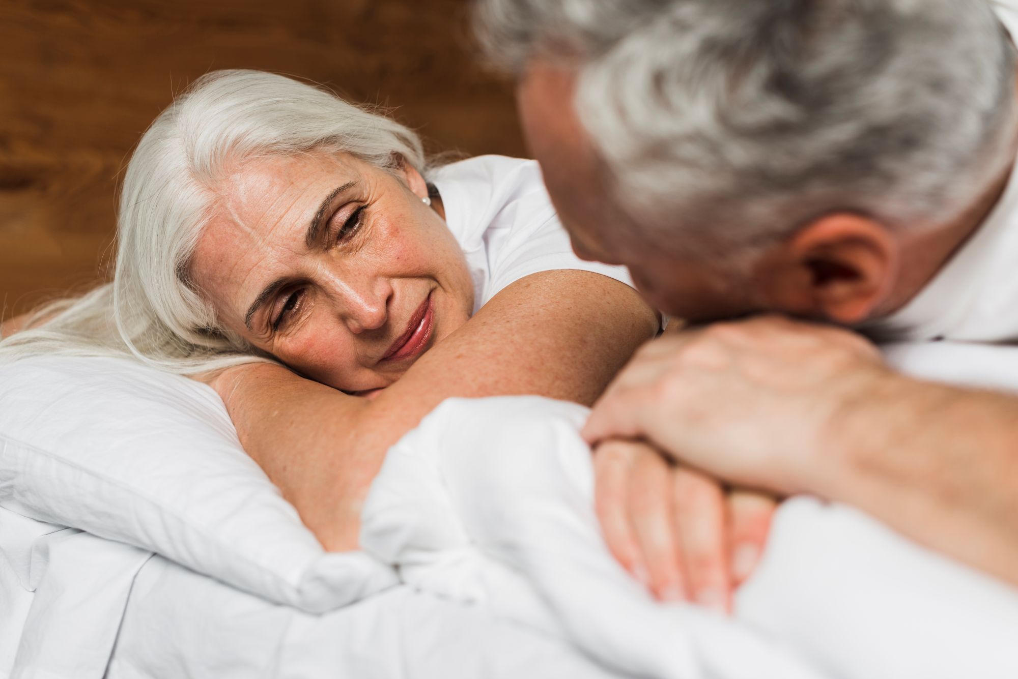 casal 50+ na cama demonstrando romantismo 