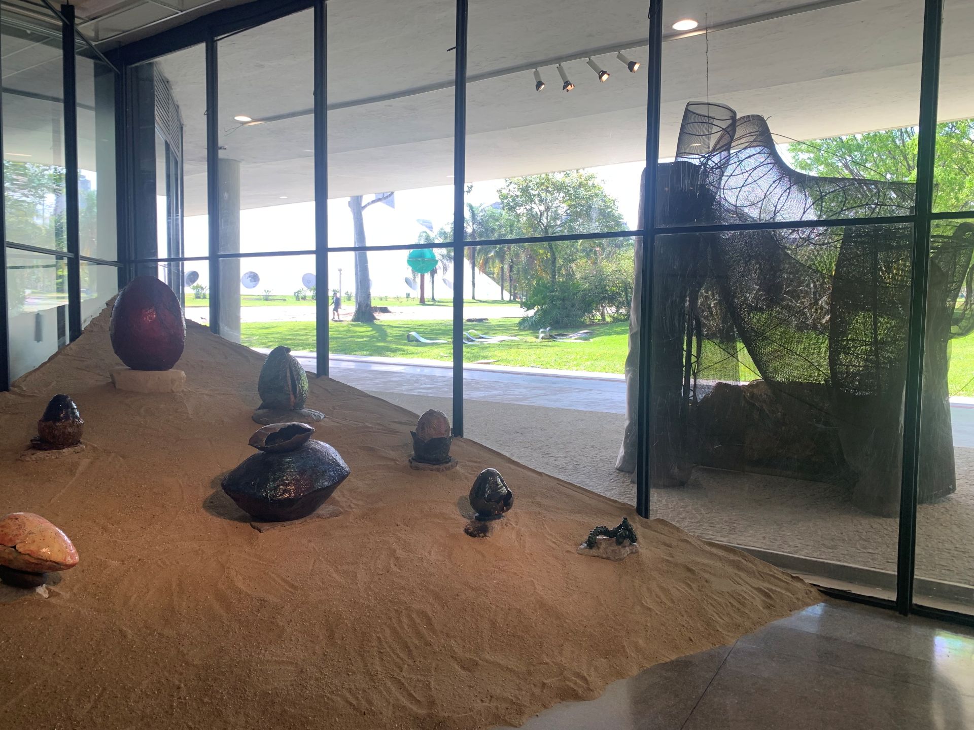 Prédio da OCA aparece atrás da obra do 39º Panorama da Arte Brasileira através da janela de vidro