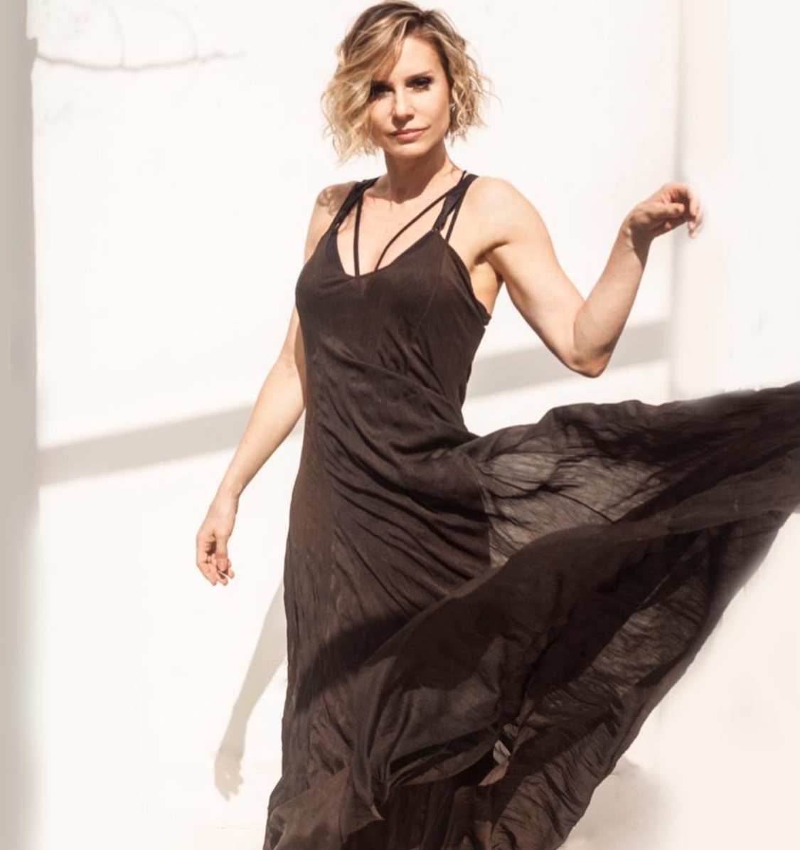 A atriz Paula Burlamarqui usa um vestido marrom