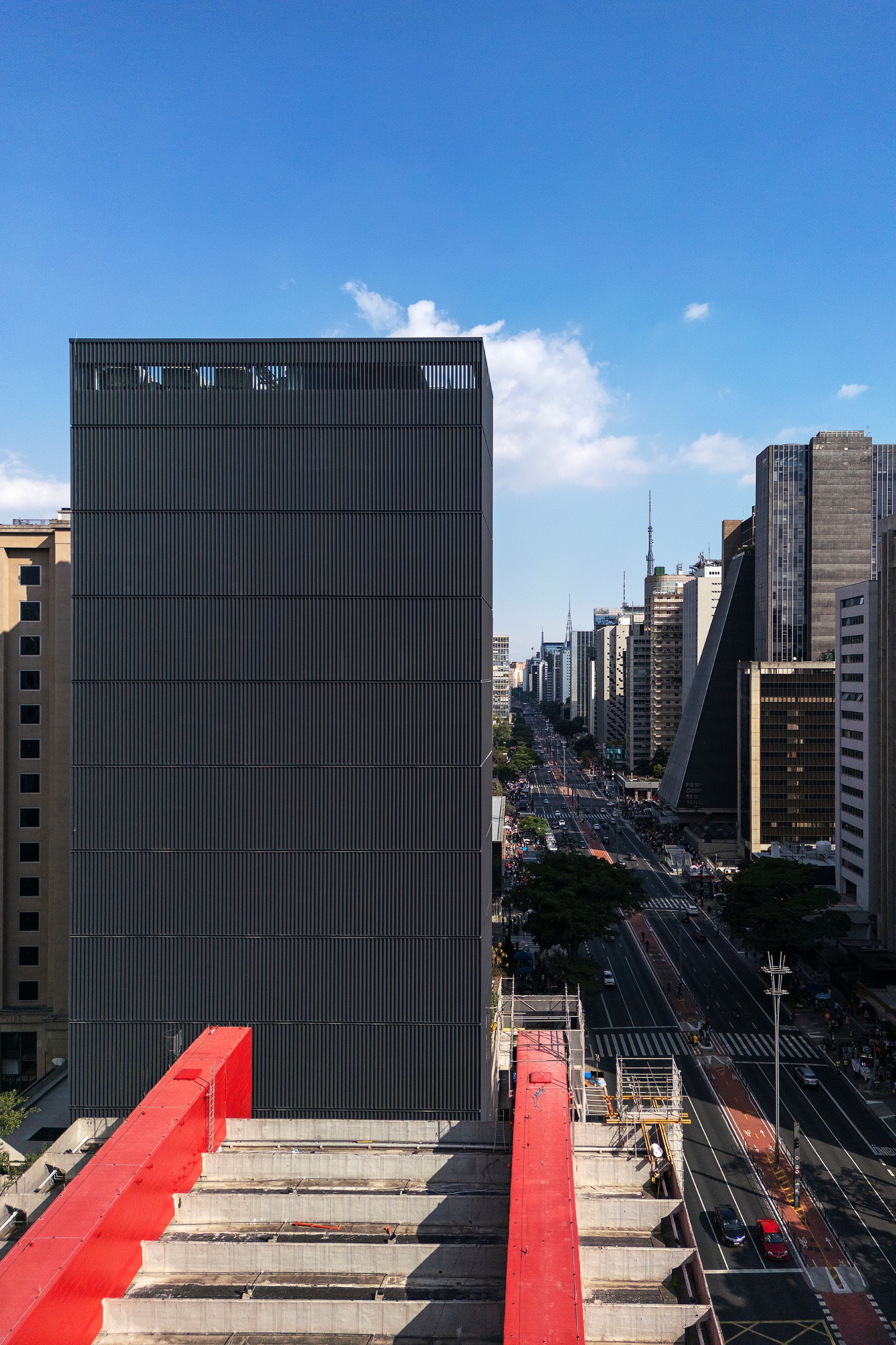 Vista lateral do prédio do Masp, vermelho, e prédio maior do anexo