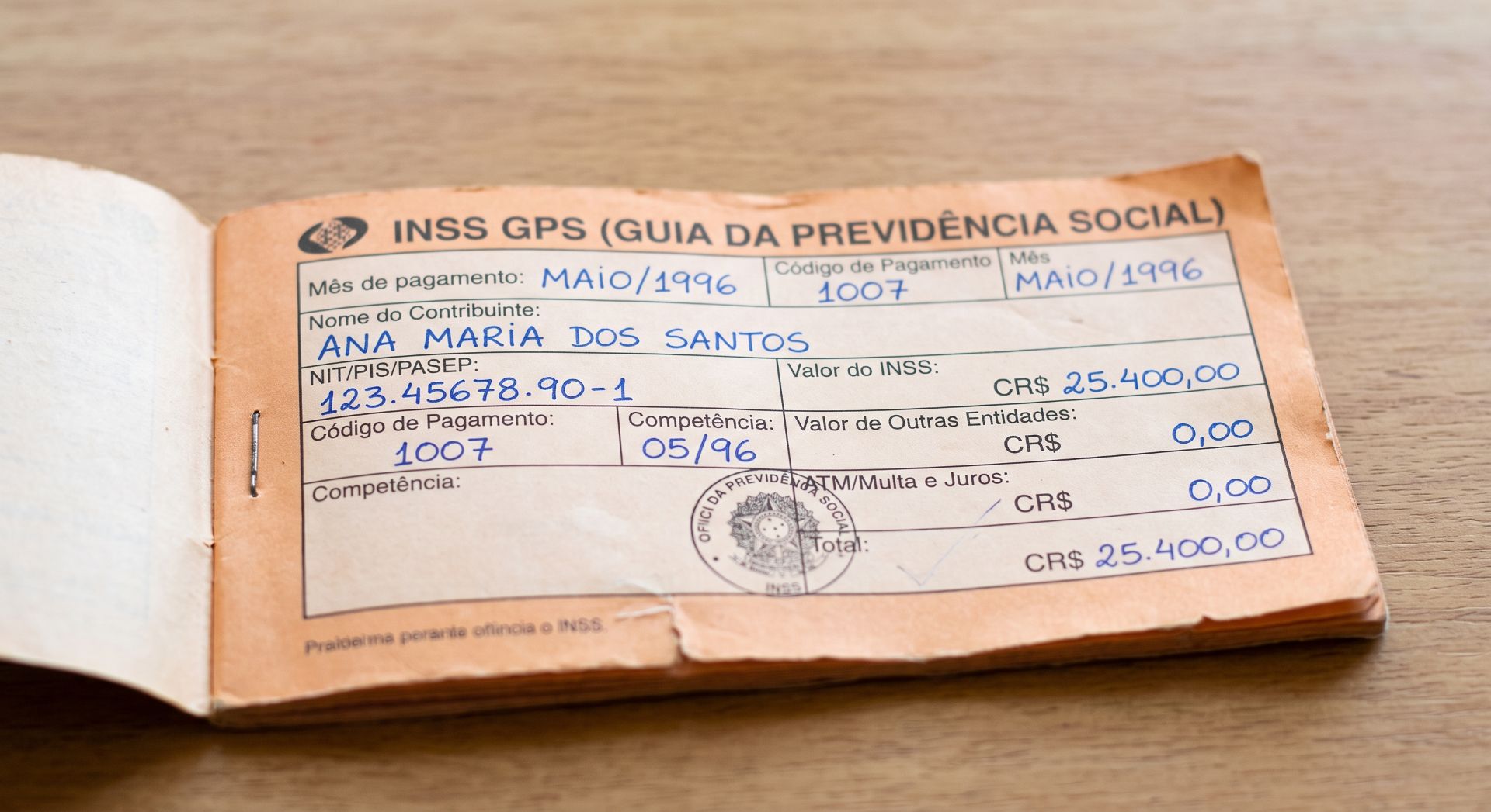 Destaque para a primeira página  do antigo carne de cor laranja  de recolhimento do INSS
